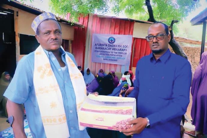A TCI staff member handing a relief package to a community elder
